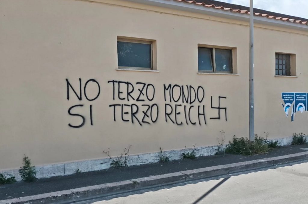 Quella scritta sul muro di Fiumicino non è una bravata: è ignoranza, vandalismo e un insulto alla memoria